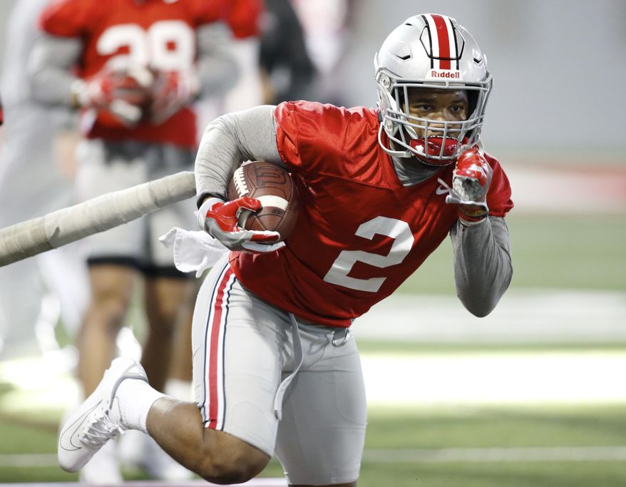 FILE - In this Wednesday, March 6, 2019 file photo, Ohio State running back J.K. Dobbins runs through a drill during an NCAA college football practice in Columbus, Ohio. J.K. Dobbins wants to make up for his “failure” last season. Despite rushing for over 1,000 yards, Dobbins calls 2018 a disappointment. He had a drop-off from his record-breaking freshman year and is determined to get back to that level and prove he’s best running back in the nation.(AP Photo/Paul Vernon, File)