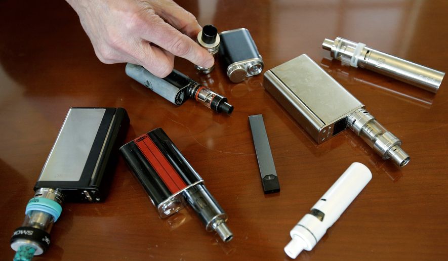 FILE — In this Tuesday, April 10, 2018 photo, a high school principal displays vaping devices that were confiscated from students at the school in Massachusetts. On Wednesday, Aug. 14, 2019, the Vapor Technology Association filed a lawsuit against the U.S. government to delay a review of electronic cigarettes. (AP Photo/Steven Senne)