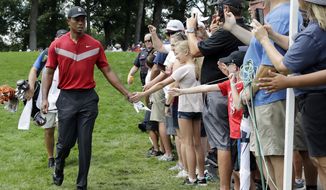 Tiger Woods, left, greets fans as he walks to the 14th fairway after hitting his tee shot during the final round of the BMW Championship golf tournament at Medinah Country Club, Sunday, Aug. 18, 2019, in Medinah, Ill. (AP Photo/Nam Y. Huh) ** FILE **