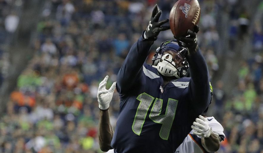 Seattle Seahawks wide receiver DK Metcalf reaches for an incomplete pass during the first half of the team's NFL football preseason game against the Denver Broncos on Thursday, Aug. 8, 2019, in Seattle. (AP Photo/Elaine Thompson)