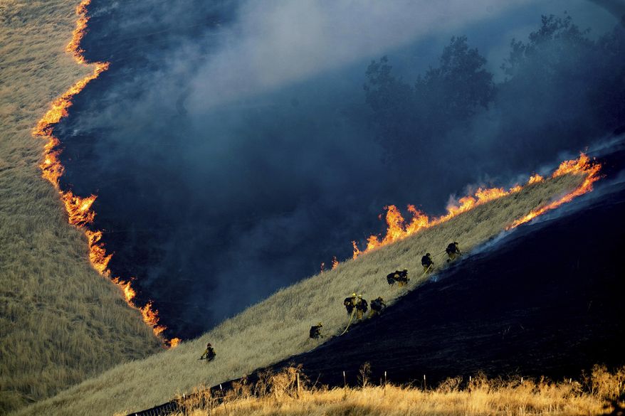 FILE - In this Aug. 3, 2019, file photo, firefighters battle the Marsh Fire near the town of Brentwood in Contra Costa County, Calif. California fire officials say acreage burned so far in 2019 is down 90% compared to the average over the past five years. (AP Photo/Noah Berger, File)