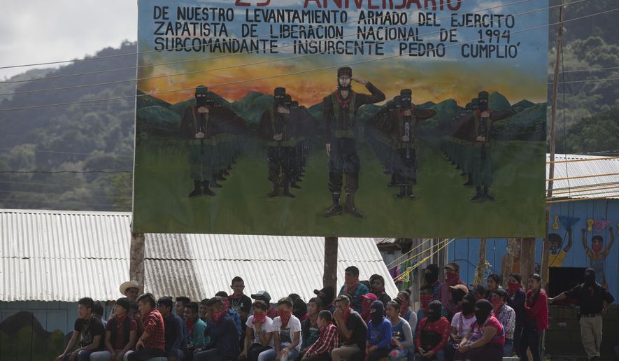 FILE - In this Jan. 1, 2019 file photo, members of the Zapatista National Liberation Army, EZLN, attend an event marking the 25th anniversary of the Zapatista uprising in La Realidad, Chiapas, Mexico. The Zapatista indigenous rebel group posted on their website Saturday, Aug. 17, 2019, that it is extending its control over so-called “autonomous” zones to 11 more areas in the southern state of Chiapas. (AP Photo/Eduardo Verdugo)