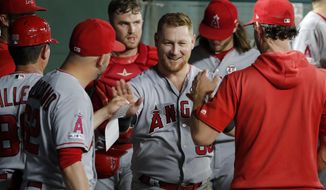Los Angeles Angels&#39; Kole Calhoun, center, is congratulated in the dugout after making an over-the-shoulder catch on a Texas Rangers&#39; Elvis Andrus flyout to end to bottom of the fourth inning of baseball game in Arlington, Texas, Monday, Aug. 19, 2019. (AP Photo/Tony Gutierrez)