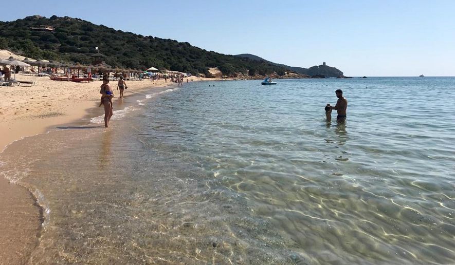 In this June 29, 2019 photo, people enjoy the white sand and pristine waters of Chia beach, on the Italian island of Sardinia, Italy. A French couple could face up to six years in jail for taking around 40 kg (88.1lbs) of white sand from Chia beach on the Italian island of Sardinia. (AP Photo/Karl A.Ritter)