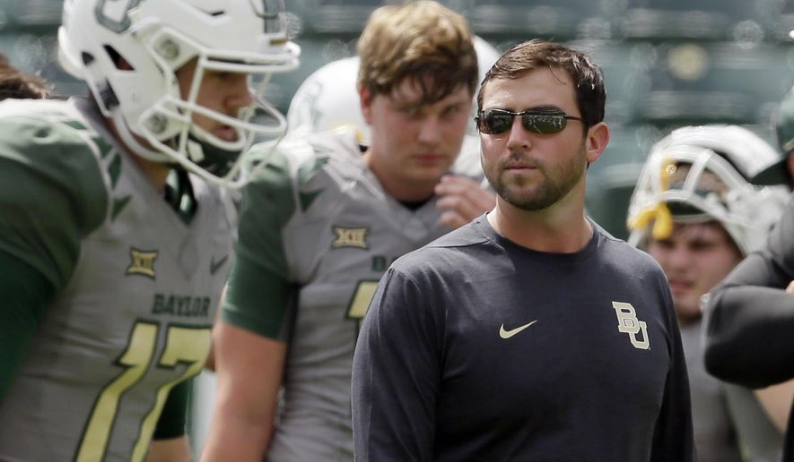FILE - In this Sept. 10, 2016, file photo, Baylor offensive coordinator Kendal Briles, right, watches players warm up before an NCAA college football game against SMU in Waco, Texas. Coach Willie Taggart drew some scrutiny for hiring Briles, who worked for his father, Art, at Baylor as that school went through a bruising scandal tied to sexual assault accusations. He will have to work around a deficient offensive line, but if the offense clicks then Taggart’s second year in Tallahassee should be much better than his first. (AP Photo/LM Otero, File)