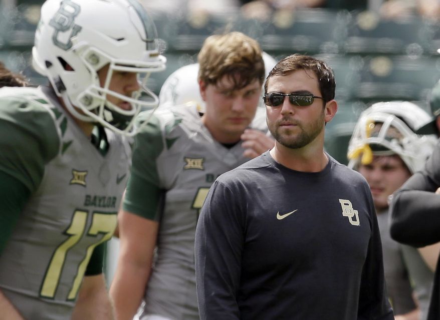 FILE - In this Sept. 10, 2016, file photo, Baylor offensive coordinator Kendal Briles, right, watches players warm up before an NCAA college football game against SMU in Waco, Texas. Coach Willie Taggart drew some scrutiny for hiring Briles, who worked for his father, Art, at Baylor as that school went through a bruising scandal tied to sexual assault accusations. He will have to work around a deficient offensive line, but if the offense clicks then Taggart’s second year in Tallahassee should be much better than his first. (AP Photo/LM Otero, File)