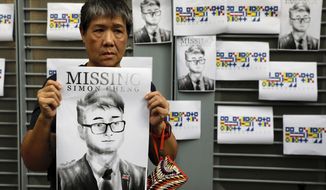 A supporter holds a poster outside of the British Consulate in Hong Kong during a rally in support of an employee of the consulate who was detained while returning from a trip to China, Wednesday, Aug. 21, 2019. China said Wednesday a staffer at the British consulate in Hong Kong has been given 15 days of administrative detention in the city of Shenzhen for violating a law on public order. (AP Photo/Vincent Yu)
