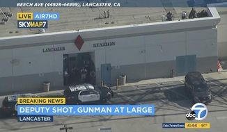 This photo taken from video provided by KABC-TV shows the outside of a Los Angeles County sheriff&#39;s station in Lancaster, Calif., on Wednesday, Aug. 21, 2019. The mayor of Lancaster says a deputy shot and wounded outside the station is going to be Okay after he visited him at the hospital. Authorities are searching for the shooter in buildings surrounding the station where the deputy was hit in the shoulder while standing in the parking lot Wednesday afternoon. (KABC-TV via AP)