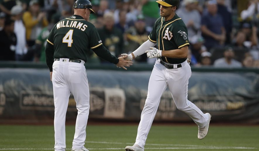 Oakland Athletics&#x27; Matt Olson, right, is congratulated by third base coach Matt Williams after hitting a two-run home run off New York Yankees pitcher Domingo German during the first inning of a baseball game Tuesday, Aug. 20, 2019, in Oakland, Calif. (AP Photo/Ben Margot)
