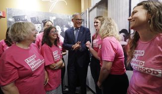 Gov. Jay Inslee talks with supporters of Planned Parenthood after speaking at a news conference addressing a change in rules on the nearly 50-year-old Title X family planning program, Thursday, Aug. 22, 2019, in Seattle. Planned Parenthood clinics in several states are charging new fees, tapping financial reserves, intensifying fundraising and warning of more unintended pregnancies and sexually transmitted diseases after its decision to quit a $260 million federal family planning program in an abortion dispute with the Trump administration. (AP Photo/Elaine Thompson)