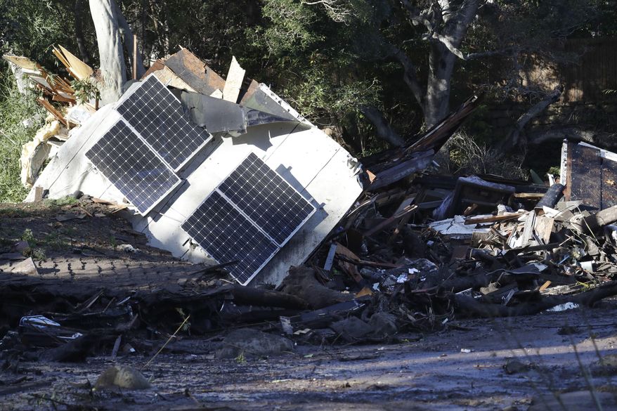 FILE - In this Jan. 10, 2018 file photo solar panels from a destroyed home and debris are shown in Montecito, Calif. California homeowners forced to rebuild because of a wildfire or other natural disaster would not have to install solar panels under a bill that has cleared the state Legislature. California is the first state in the country to require new homes to install solar panels. The new rules take effect Jan. 1, 2020. (AP Photo/Marcio Jose Sanchez, File)