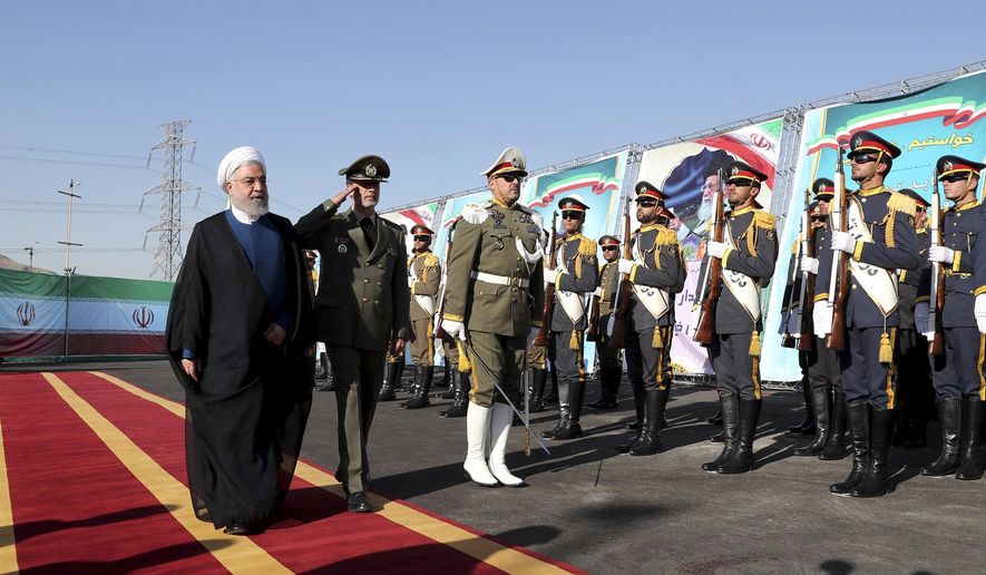 In this photo released by the official website of the office of the Iranian Presidency, President Hassan Rouhani, left, reviews an honor guard as he is accompanied by his Defense Minister Gen. Amir Hatami during a ceremony to unveil Iran-made Bavar-373 air-defense missile system, Iran, Thursday, Aug. 22, 2019. Iran says the Bavar-373 is a long-range surface-to-air missile system able to recognize up to 100 targets at a same time and confront them with six different weapons. (Iranian Presidency Office via AP)
