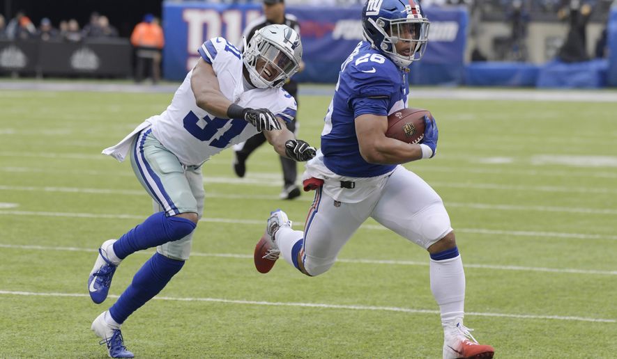 FILE - In this Dec. 30, 2018, file photo, Dallas Cowboys' Byron Jones, left, tries to catch New York Giants' Saquon Barkley during the first half of an NFL football game in East Rutherford, N.J. The dynamic second-year running back is worth the price of admission and can help the team pull off upsets by himself. (AP Photo/Bill Kostroun, File)