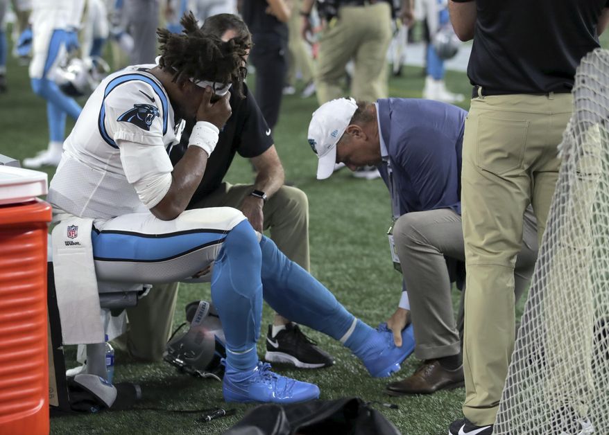 Carolina Panthers quarterback Cam Newton (1) receives attention on the sideline after an injury in the first half of an NFL preseason football game against the New England Patriots, Thursday, Aug. 22, 2019, in Foxborough, Mass. (AP Photo/Charles Krupa)