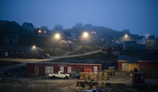 FILE - In this Aug. 15, 2019, file photo, early morning fog shrouds homes in Kulusuk, Greenland. As warmer temperatures cause the ice to retreat the Arctic region is taking on new geopolitical and economic importance, and not just the United States hopes to stake a claim, with Russia, China and others all wanting in. (AP Photo/Felipe Dana, File)