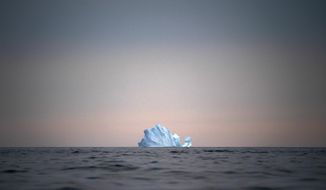FILE - In this Aug. 15, 2019, file photo, a large Iceberg floats away as the sun sets near Kulusuk, Greenland. As warmer temperatures cause the ice to retreat the Arctic region is taking on new geopolitical and economic importance, and not just the United States hopes to stake a claim, with Russia, China and others all wanting in. (AP Photo/Felipe Dana, File)