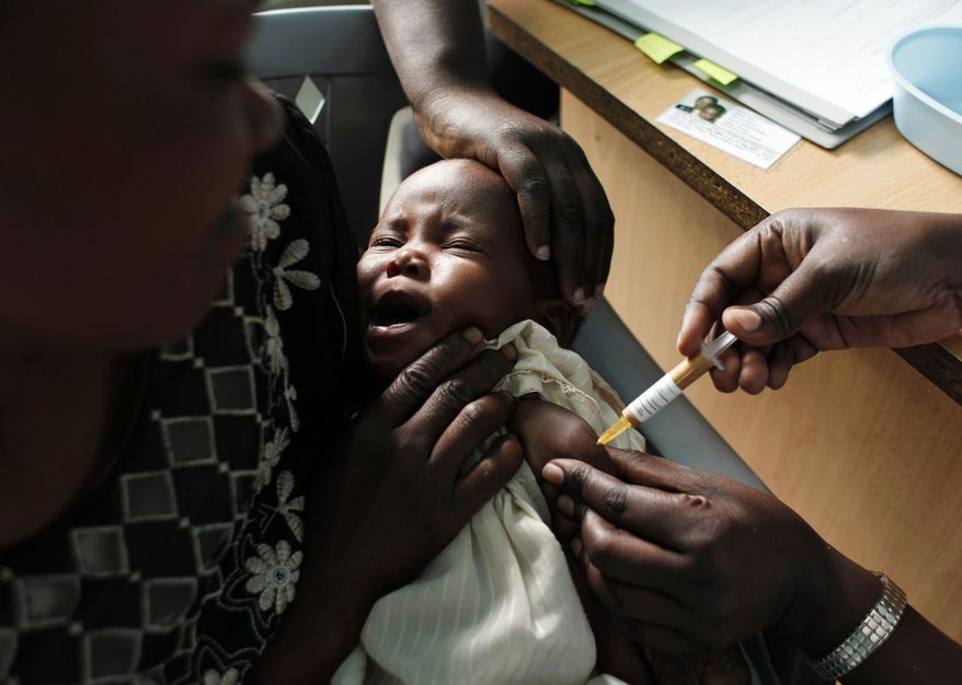 FILE - In this Oct. 30, 2009 file photo, a mother holds her baby receiving a new malaria vaccine as part of a trial at the Walter Reed Project Research Center in Kombewa in Western Kenya. The World Health Organization said Thursday Aug. 22, 2019, it’s theoretically possible to wipe out malaria, but probably not with the flawed vaccine and other control methods being used at the moment. (AP Photo/Karel Prinsloo, File)