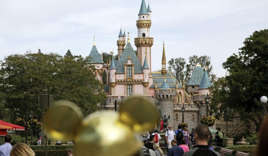 In this Jan. 22, 2015, file photo, visitors walk toward Sleeping Beauty&#x27;s Castle in the background at Disneyland Resort in Anaheim, Calif. (AP Photo/Jae C. Hong, File)