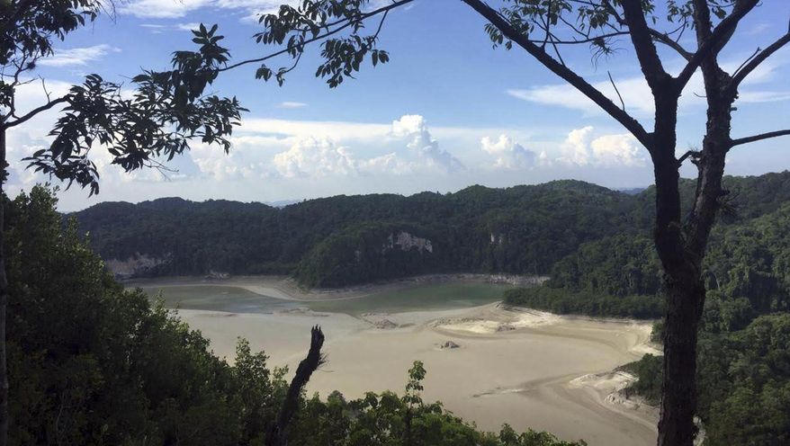 In this photo provided by Mexico's National Commission for Protected Nature Areas, the diminishing waters of the Metzabok Lagoon are seen amidst its drying lake bed, in the Lacandon jungle of Chiapas State in southern Mexico, in the first half of August, 2019. During the month of August, the Metzabok lake, which normally covers 220 acres (89 hectares), dried up completely, leaving cracked mud where the surrounding jungle used to reflect in the translucent waters and Lacandon Indians traveled by canoe. (CONANP via AP)
