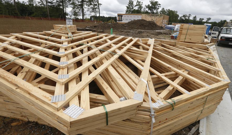 FILE - In this June 13, 2019, file photo stacks of building materials are stacked up near new home under construction in Mechanicsville, Va. On Friday, Aug. 23, the Commerce Department reports on sales of new homes in July. (AP Photo/Steve Helber, File)