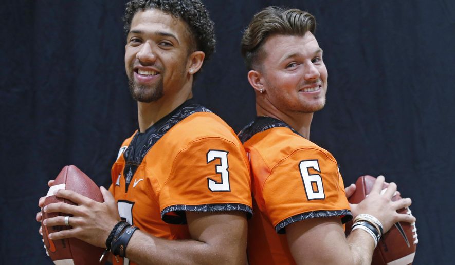 FILE - In this Saturday, Aug. 3, 2019, file photo, Oklahoma State quarterbacks Spencer Sanders, left, and Dru Brown pose for a photo during the NCAA college football team's media day in Stillwater Okla. Oklahoma State hasn’t named a starting quarterback yet for its season opener next Friday night at Oregon State, as coach Mike Gundy continues to evaluate redshirt freshman Spencer Sanders and Hawaii grad transfer Dru Brown for the job. At this point, it seems likely that both will see action. (AP Photo/Sue Ogrocki, File)