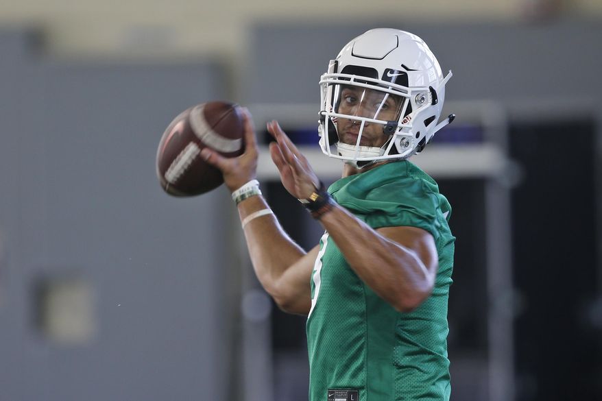 FILe - In this Aug. 1, 2019, file photo, Oklahoma State quarterback Spencer Sanders throws during an NCAA college football practice in Stillwater, Okla. Oklahoma State hasn’t named a starting quarterback yet for its season opener next Friday night at Oregon State, as coach Mike Gundy continues to evaluate redshirt freshman Spencer Sanders and Hawaii grad transfer Dru Brown for the job. At this point, it seems likely that both will see action. (AP Photo/Sue Ogrocki, File)