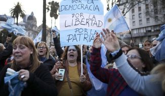 A woman holds a sign reading in Spanish &amp;quot;For democracy, for liberty, for country&amp;quot; during march in support of President Mauricio Macri, in Buenos Aires, Argentina, Saturday, Aug. 24, 2019. Following a social media campaign large numbers of people gathered in the center of Buenos Aires to show their support for Macri&#39;s administration. (AP Photo/Natacha Pisarenko)