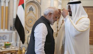 In this photograph made available by the state-run WAM news agency, Indian Prime Minister Narendra Modi, left, receives a medal during his induction to the Order of Zayed from Sheikh Mohammed bin Zayed Al Nahyan, right, in Abu Dhabi, United Arab Emirates, Saturday, Aug. 24, 2019. Modi is on a trip to both the United Arab Emirates and Bahrain, reinforcing ties between India and the Gulf Arab nations as he pursues stripping statehood from the disputed Muslim-majority region of Kashmir. (Hamad al-Kaabi - Ministry of Presidential Affairs/WAM via AP)