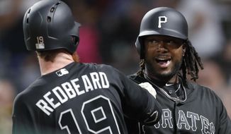 Pittsburgh Pirates&#39; Josh Bell, left, celebrates with on-deck batter Colin Moran after hitting a two-run home run off Cincinnati Reds relief pitcher Kevin Gausman in the seventh inning of a baseball game Saturday, Aug. 24, 2019, in Pittsburgh. (AP Photo/Keith Srakocic)
