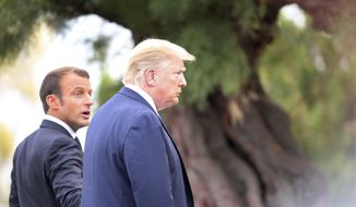 French President Emmanuel Macron welcomes President Donald Trump at the Biarritz lighthouse, southwestern France, ahead of a working dinner Saturday, Aug.24, 2019. Shadowed by the threat of global recession, a U.S. trade war with China and the possibility of one against Europe, the posturing by leaders of the G-7 rich democracies began well before they stood together for a summit photo. (AP Photo/Markus Schreiber)