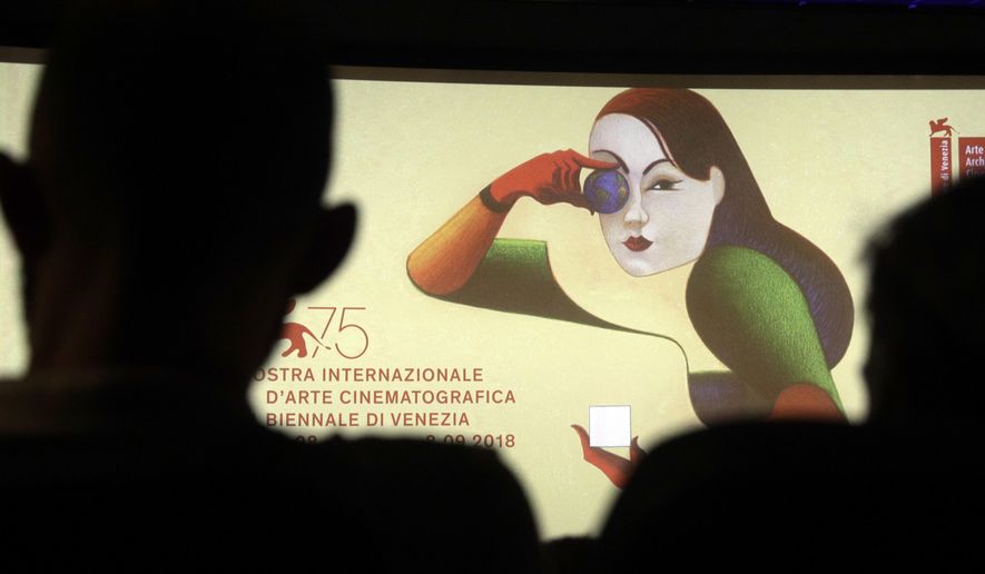 FILE - In this Wednesday, July 25, 2018, file photo, journalists are silhouetted against the logo presenting the 75th edition of the festival, during its presentation in Rome. It may be the oldest film festival in the world but at 76, the Venice International Film Festival is more relevant, and divisive, than ever. Kicking off Wednesday, Aug. 28, 2019,  on the sleepy beach town of Lido, this year’s festival has already become a hotbed for discussion about the Oscar hopefuls launching there, its embrace of controversial filmmakers like Roman Polanski and Nate Parker in the #MeToo era and its lack of female directors. (AP Photo/Gregorio Borgia, File)