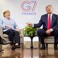 U.S. President Donald Trump, accompanied by German Chancellor Angela Merkel, left, speaks to reporters during a bilateral meeting at the G-7 summit in Biarritz, France, Monday, Aug. 26, 2019. (AP Photo/Andrew Harnik)