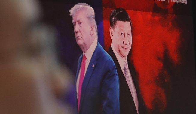 A computer screen shows images of Chinese President Xi Jinping, right, and U.S. President Donald Trump as a currency trader works at the foreign exchange dealing room of the KEB Hana Bank headquarters in Seoul, South Korea, Monday, Aug. 26, 2019. Asian shares tumbled Monday after the latest escalation in the U.S.-China trade war renewed uncertainties about global economies, as well as questions over what Trump might say next. (AP Photo/Ahn Young-joon)