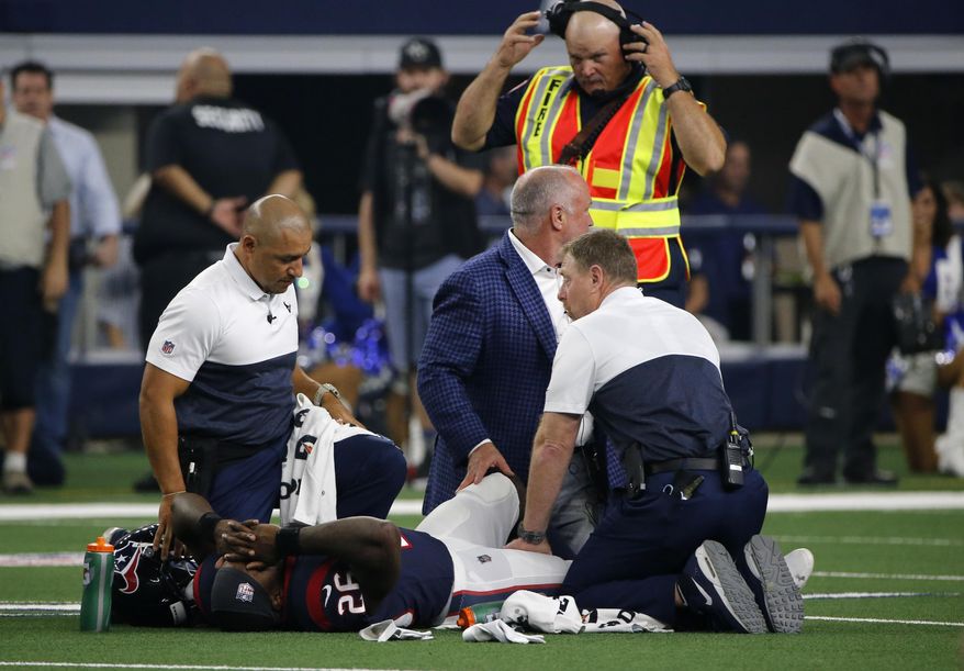 Houston Texans staff check on running back Lamar Miller (26) after he suffered an unknown injury in the first half of a preseason NFL football game against the Dallas Cowboys in Arlington, Texas, Saturday, Aug. 24, 2019. (AP Photo/Michael Ainsworth)