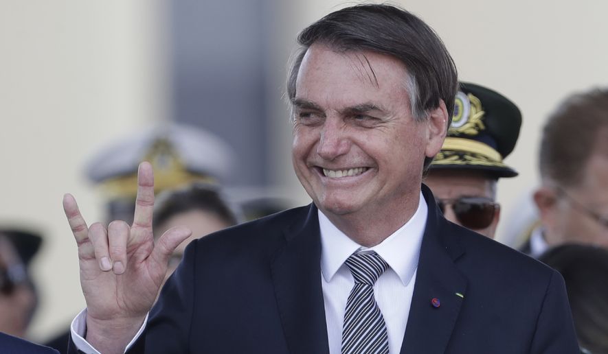 Brazils President Jair Bolsonaro makes a signal with his hand during a military ceremony for the Day of the Soldier, at Army Headquarters in Brasilia, Brazil, Friday, Aug. 23, 2019. Brazilian President Jair Bolsonaro says he&#39;s leaning toward sending the army to help fight Amazon fires that have alarmed people across the globe. (AP Photo/Eraldo Peres)