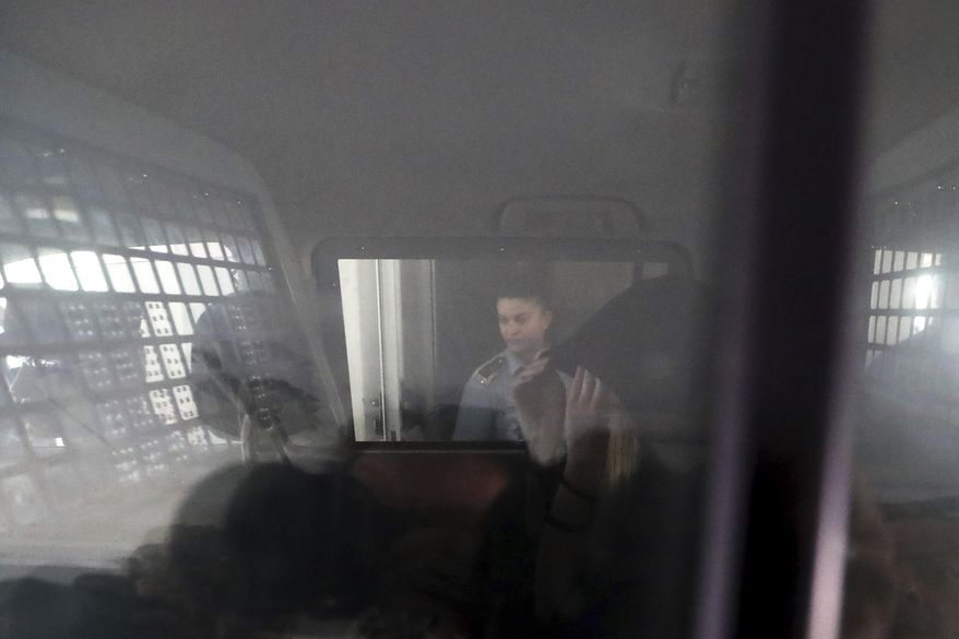 A 19-year old British woman, is seen inside a police vehicle with head covered, as she leaves the Famagusta court in Paralimni, Cyprus, Tuesday, Aug. 27, 2019, after pleading not guilty to a public mischief charge. The Cyprus court judge set the start of the trial for Oct. 2 and released the woman on bail, finding it "proper and fair" to do so after having spent nearly two months in police detention. (AP Photo/Petros Karadjias)