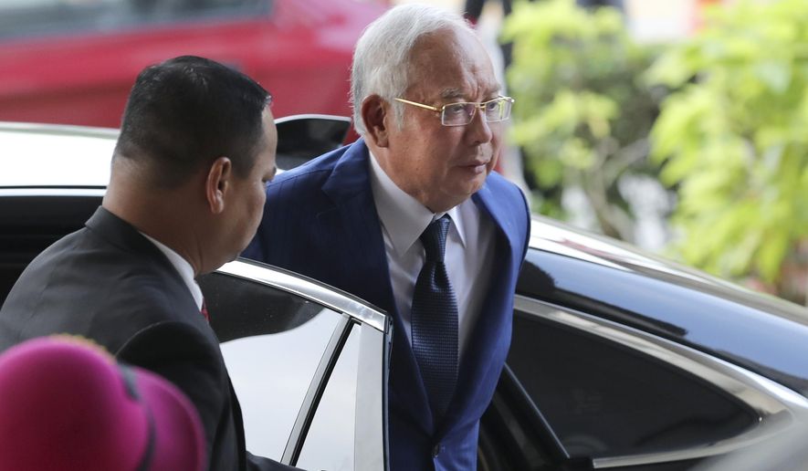 Former Malaysian Prime Minister Najib Razak, right, arrives at Kuala Lumpur High Court in Kuala Lumpur, Malaysia, Tuesday, Aug. 27, 2019. Malaysian prosecutors have wrapped up their case against Najib in his first corruption trial. Najib faces 42 charges of corruption, abuse of power and money laundering in five criminal cases linked to the multibillion-dollar looting of the 1MDB state investment fund. His second trial is due to begin Wednesday but could be delayed. Najib denies wrongdoing and accuses the new government of seeking political vengeance. (AP Photo/Vincent Thian)