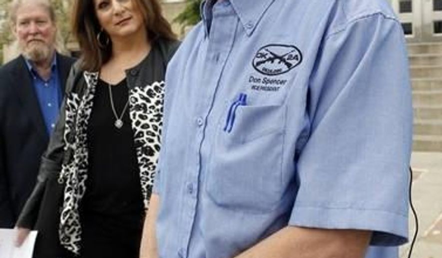 FILE - In a Wednesday, April 15, 2015 file photo, Don Spencer, vice president of the Oklahoma Second Amendment Association and Lana Cohlmia, attorney speak to the media outside the Cleveland County Courthouse in Norman, Okla. The Oklahoma Second Amendment Association is challenging efforts that would put on hold a new permitless carry law until voters weigh in on the issue. (Steve Sisney/The Oklahoman via AP)