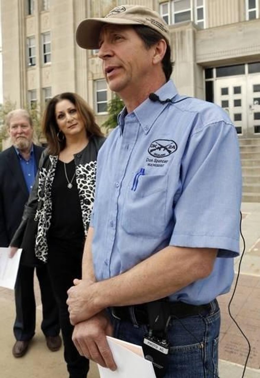 FILE - In a Wednesday, April 15, 2015 file photo, Don Spencer, vice president of the Oklahoma Second Amendment Association and Lana Cohlmia, attorney speak to the media outside the Cleveland County Courthouse in Norman, Okla. The Oklahoma Second Amendment Association is challenging efforts that would put on hold a new permitless carry law until voters weigh in on the issue. (Steve Sisney/The Oklahoman via AP)