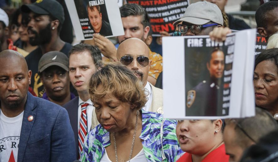Gwen Carr, center, the mother of chokehold victim Eric Garner, listens during a news conference as Loyda Colon, co-director of the Justice Committee, call for charging other officers involved in the death of Garner, after NYPD Commissioner James O'Neill announced his decision to fire NYPD officer Daniel Pantaleo for the 2014 death of Garner, Monday Aug. 19, 2019, in New York. (AP Photo/Bebeto Matthews)