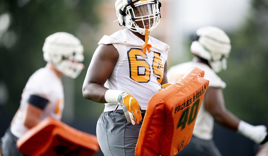 In this Aug. 2, 2019 photo, Tennessee freshman offensive lineman Wanya Morris (64) runs a drill during NCAA college football practice in Knoxville, Tenn. Tennessee head coach Jeremy Pruitt knows the perils of playing freshmen. But as much as Pruitt wants to remain patient, Tennessee's roster situation demands that he gives some opportunities to his youngest players. (Calvin Mattheis//Knoxville News Sentinel via AP)