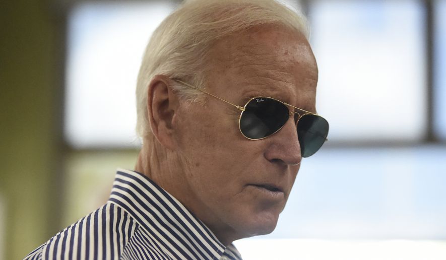 Democratic presidential candidate former Vice President Joe Biden pays for his order at a Krispy Kreme following a campaign town hall on Wednesday, Aug. 28, 2019, in Spartanburg, S.C. (AP Photo/Meg Kinnard)