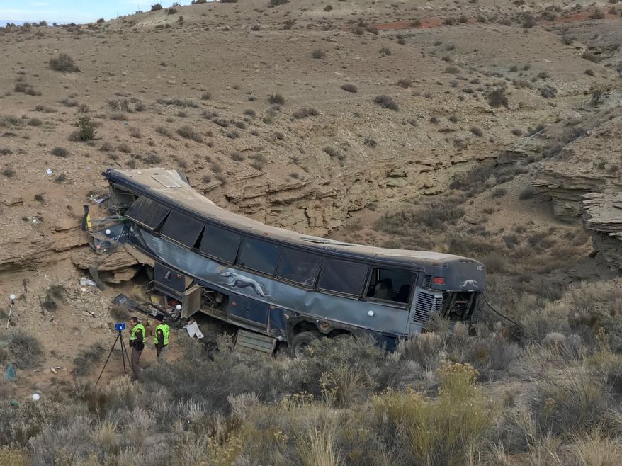 FILE - This Jan. 1, 2018, file photo, shows the aftermath of a Greyhound bus crash in Emery County, Utah. A second passenger has sued the Greyhound bus company and a driver who authorities say fell asleep before the bus careened off a road in the Utah desert two years ago, killing one person and injured 12 others. Clemente Velazquez of Rogers, Arkansas, says in a lawsuit filed in July that he's incurred more than $75,000 in damages from medical bills and lost wages after he suffered neck and back injuries and has been psychologically traumatized by the crash New Year's Eve 2017. (Ben Tidswell/The Deseret News via AP, File)