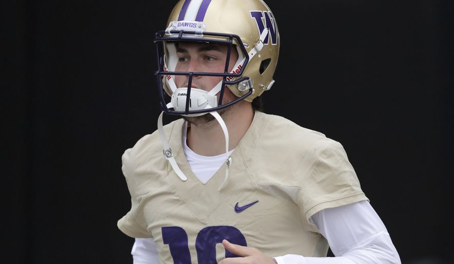 FILE - In this April 3, 2019, file photo, Washington quarterback Jacob Eason jogs to the field for NCAA college football practice in Seattle. Eason replaces Jake Browning, who threw for 3,192 yards with 16 touchdowns last season, leading the Huskies to a 10-4 record and the Pac-12 championship. Browning now plays for the NFL’s Minnesota Vikings.(AP Photo/Ted S. Warren, File)