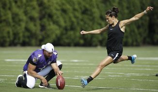Baltimore Ravens&#x27; Sam Koch holds the ball for United States soccer player Carli Lloyd as she attempts to kick a field goal after the Philadelphia Eagles and the Baltimore Ravens held a joint NFL football practice in Philadelphia, Tuesday, Aug. 20, 2019. (AP Photo/Matt Rourke)