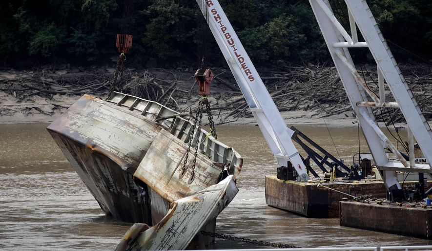 One of two sunken barges is removed from the Webbers Falls Lock and Dam 16 Tuesday, Aug. 27, 2019. The barges broke loose up river and sunk during May's historic flooding. (Mike Simons/Tulsa World via AP)