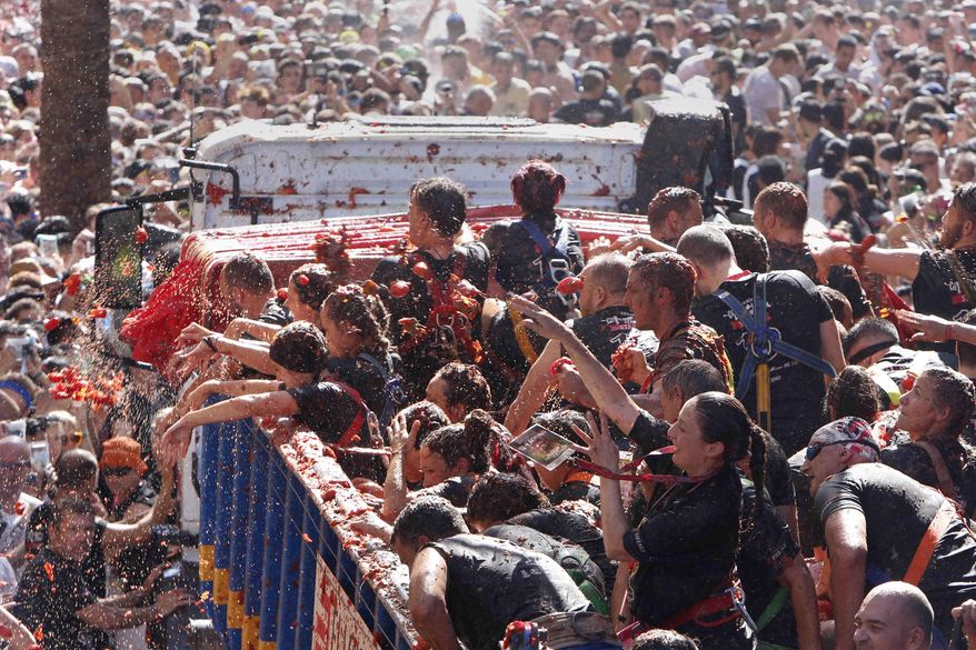 Revellers throw tomatoes at each other during the annual "Tomatina", tomato fight fiesta in the village of Bunol near Valencia, Spain, Wednesday, Aug. 28, 2019. (AP Photo/Alberto Saiz)