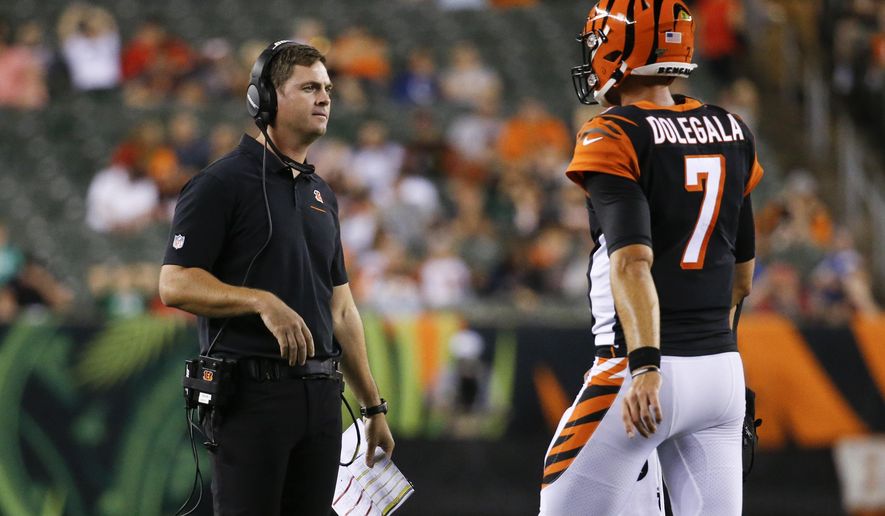 Cincinnati Bengals coach Zac Taylor, left, meets with quarterback Jake Dolegala (7) during the second half of the team's NFL preseason football game against the Indianapolis Colts, Thursday, Aug. 29, 2019, in Cincinnati. (AP Photo/Frank Victores)