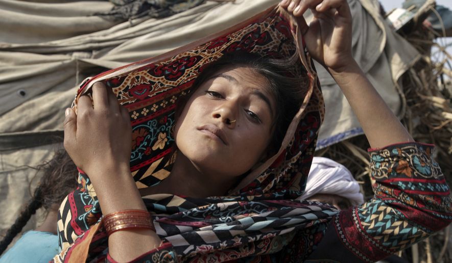 In this Tuesday, Dec. 20, 2016, file photo, Saima, who married an older man in her early teens, fixes her scarf during an interview in Jampur, Pakistan. (AP Photo/K.M. Chaudhry) ** FILE **
