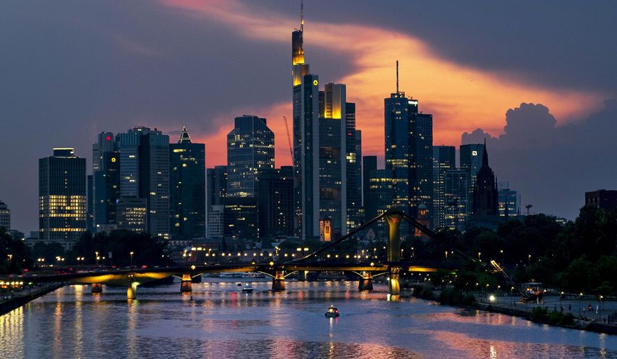 Two people steer their paddle boards over the river Main with the buildings of the banking district in background in Frankfurt, Germany, late Tuesday, Aug. 27, 2019. (AP Photo/Michael Probst)